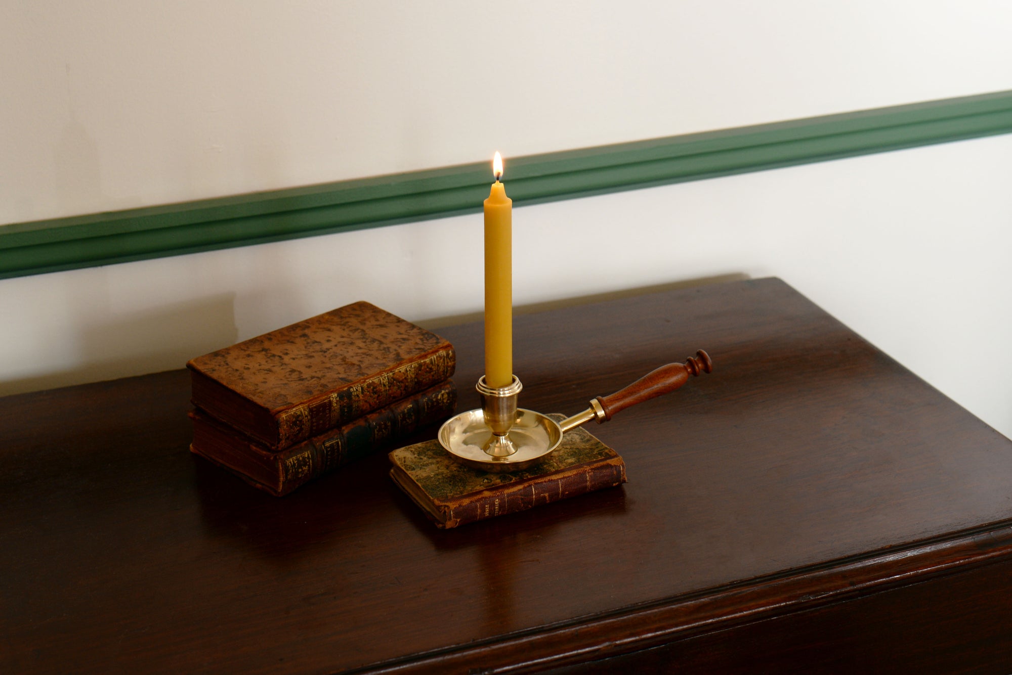 1700s Beeswax Candle and Wooden Handled Chamberstick on Book