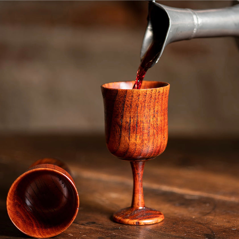 Wine being poured into a wooden chalice from Samson Historical. Browse all 18th Century drinking vessels here.