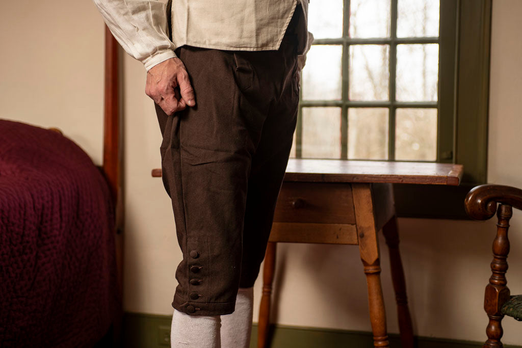 18th Century Brown Cotton Breeches modeled by a man in a Colonial American home.